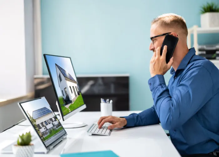 online-jobs-in-real-estate-appraiser-talking-on-phone-while-viewing-properties-on-computer